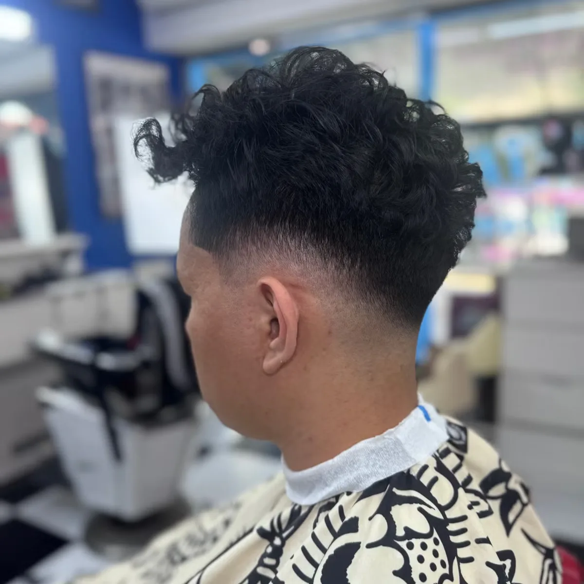 Textured curly top with a clean low fade