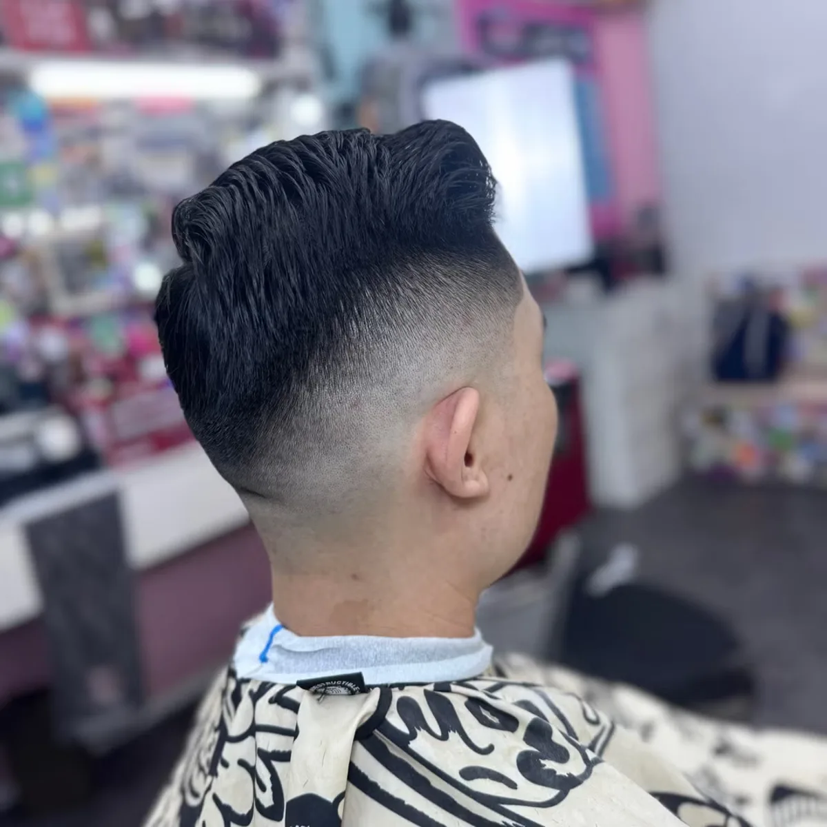 High skin fade with a sharp quiff and lined edges